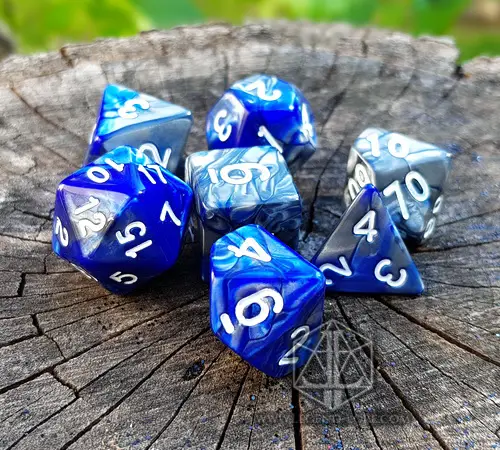 Celestial Dragon set of seven bicolor blue and silver polyhedral dice with white numbers on a weathered tree stump