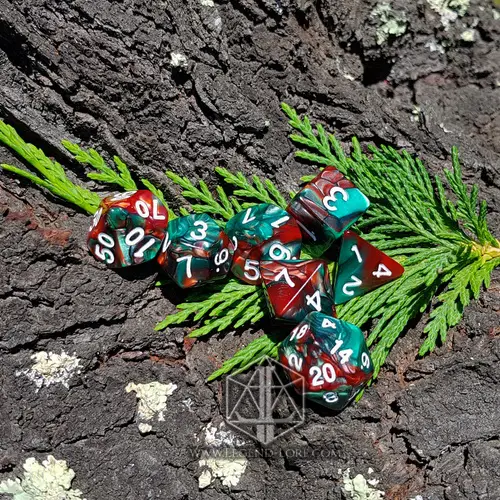 Christmas RPG dice set: seven swirled red and green polyhedral dice with white numbers on bark and cedar sprigs