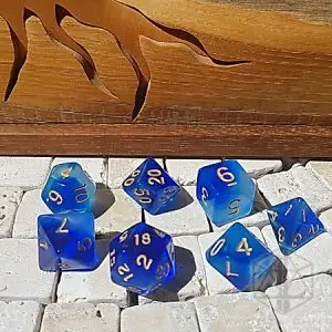 Set di dadi GDR Cloudy Sapphire: sette dadi poliedrici blu nebula traslucidi con numeri dorati su piastrelle di pietra