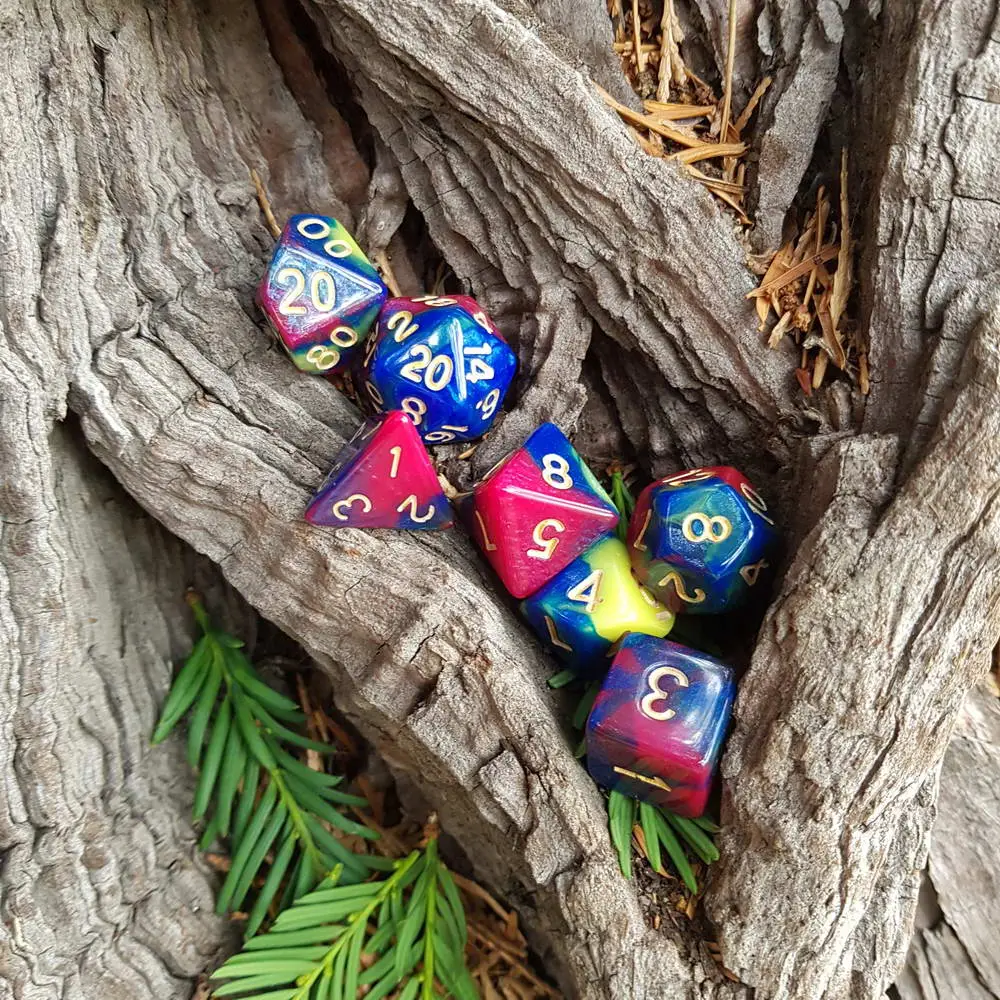 Distopia - RPG Dice Set 2 Distopia set of seven polyhedral dice in blue, pink and yellow swirls with gold numbers, nestled in tree bark