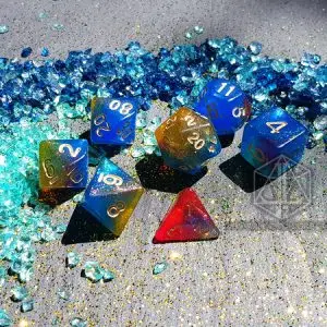 Set di dadi GDR Dying Galaxy: sette dadi in resina glitterata blu, oro e rossa con numeri dorati tra gemme di vetro blu