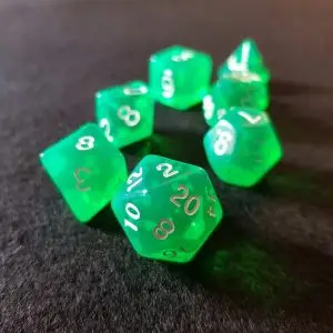 Set di dadi GdR Emerald: sette dadi poliedrici verde traslucido con numeri bianchi su un panno scuro