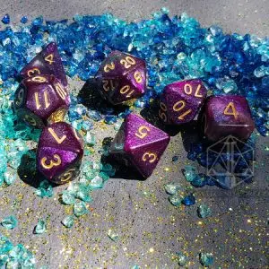 Set di dadi GdR Forgotten Nebula: sette dadi viola galassia glitterati con numeri dorati su frammenti di vetro blu e turchese