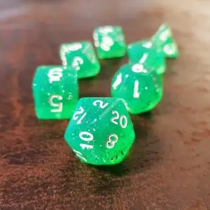 Set di dadi GdR Green Dragon: sette dadi poliedrici verdi trasparenti con glitter e numeri bianchi su legno scuro