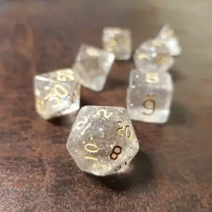 Set di dadi GdR Iridescent Smoke: sette dadi poliedrici trasparenti con glitter argento e numeri dorati su legno scuro