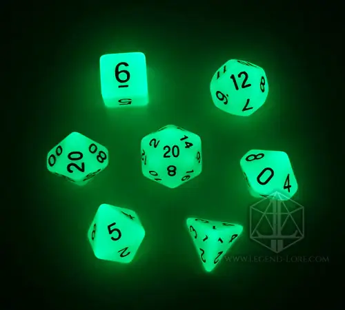 Set di sette dadi poliedrici Live Ash che brillano di verde acceso al buio, con numeri neri, su sfondo nero