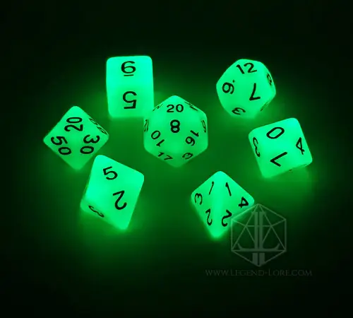 Set di sette dadi poliedrici Live Ash che brillano di verde intenso al buio, con numeri neri