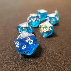 Set di dadi GdR Opencast Mine: sette dadi in resina blu trasparente con inclusioni di foglia oro e numeri argentati