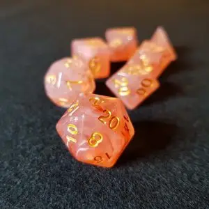 Set di dadi GDR Orange Blossom: sette dadi poliedrici arancioni traslucidi con venature bianche e numeri dorati su feltro scuro