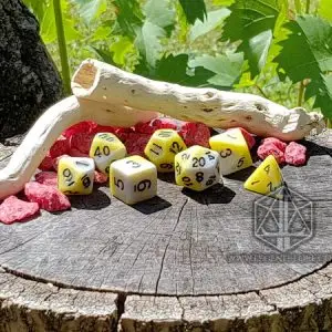 Set di sette dadi poliedrici Pale Death bianchi e gialli con numeri neri su un ceppo, con legno secco e sassi rossi