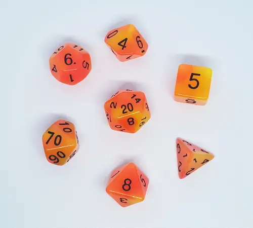 Persistent Twilight set of seven polyhedral dice in translucent orange and yellow with black numbers on a white background