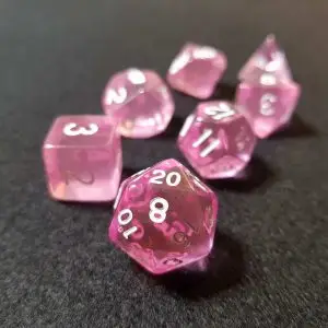 Set di dadi GDR Pink Sapphire: sette dadi poliedrici rosa trasparenti con numeri bianchi su feltro grigio scuro