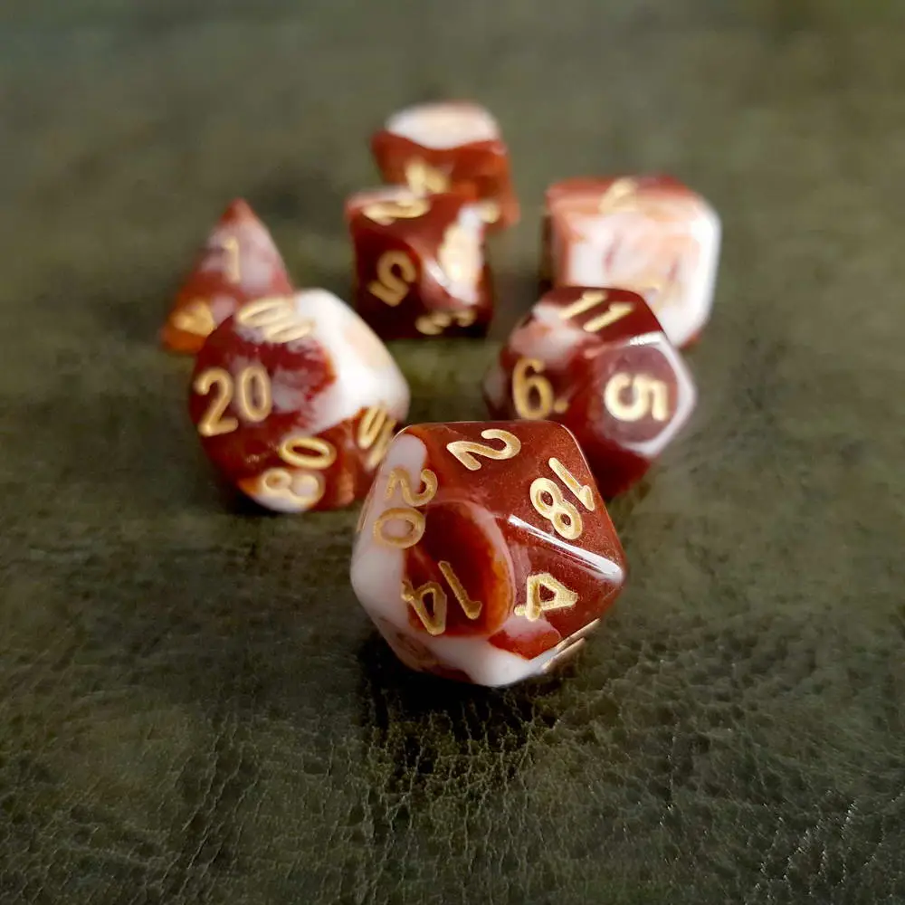 Raspberry RPG dice set: seven polyhedral dice swirled dark red and white with gold numbers on green leather