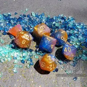 Set di sette dadi Rising Galaxy traslucidi arancio, rosa e blu con glitter e numeri dorati su frammenti di vetro azzurri