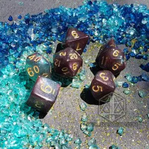Set di dadi GDR Sea Trench: sei dadi marrone-verde con glitter e numeri dorati su sassolini di vetro blu e turchesi