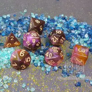Set di dadi GdR Shining Nebula: sette dadi traslucidi viola, rosa e arancio glitterati con numeri dorati su pietre blu e turchesi
