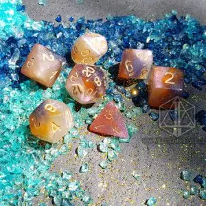 Set di sette dadi poliedrici Stardust Slime in resina bianca, rosa e ambra con numeri dorati su frammenti di vetro blu e turchese
