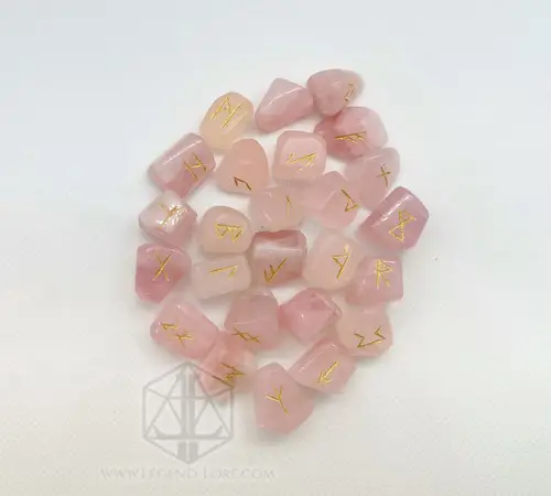Rune divinatorie Crystal Petals: pietre burattate di quarzo rosa con simboli Futhark incisi in oro su sfondo bianco