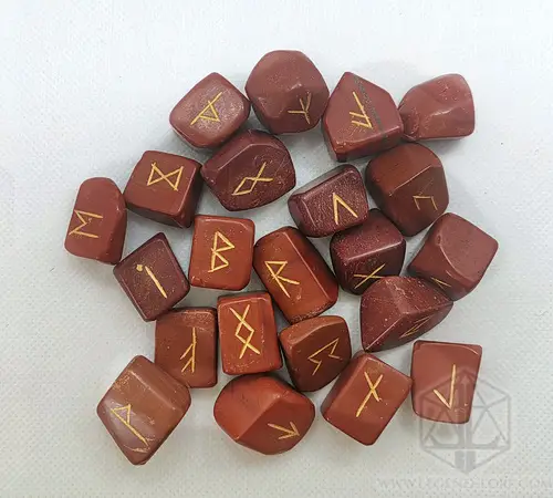 Cursed Spines Divination Runes: set of red jasper stones engraved with gold Elder Futhark runes on a white background