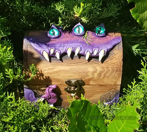 Mimic Boss - RPG Dice Box 1 Mimic Boss RPG dice box: wooden chest with purple monster lid, three green eyes, white fangs and brass latch among greenery