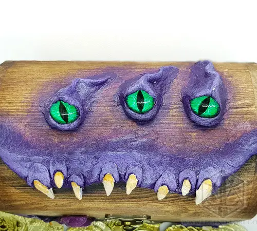 Mimic Boss - RPG Dice Box 4 Mimic Boss RPG dice box in brown wood with purple sculpted monster face, three green slit eyes and ivory fangs