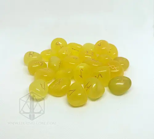 Sun Tongues divination runes: pile of polished yellow onyx stones engraved with gold Elder Futhark runes