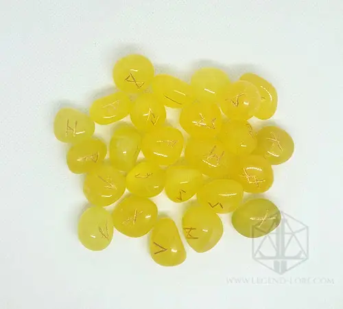 Sun Tongues divination runes: polished yellow stones engraved with gold Elder Futhark symbols on a white background