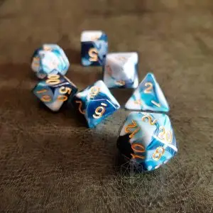 Set di dadi GdR Blueberry: sette dadi poliedrici a spirale blu, blu scuro e bianco con numeri dorati su pelle scura
