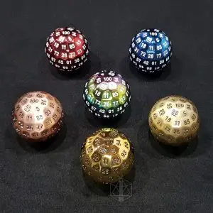 Dadi Imperial D100 jumbo in metallo rosso, blu, arcobaleno, rame, ottone e oro disposti su feltro nero
