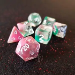 Set di sette dadi poliedrici Rising Spring in rosa, trasparente e verde con numeri bianchi su tessuto scuro brillantinato