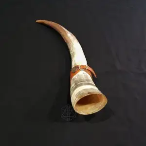 Royal Horn, grande corno bovino ricurvo nei toni crema e marrone con cinghia in cuoio e fibbia, su tessuto nero