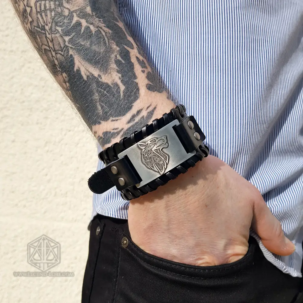 Bracelet of the Pack, black braided PU-leather cuff with silver Celtic knot wolf plate, worn on a tattooed wrist