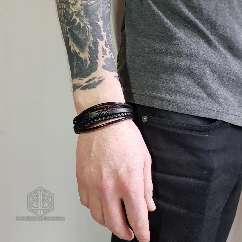 Night Pathfinder - Viking Leather Bracelet 2 Night Pathfinder Viking bracelet with black braided and smooth leather strands worn on a tattooed man's wrist