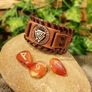 Ancient Valknut Viking Leather Bracelet, brown laced band with copper rune-ringed Valknut plate, on a stone with carnelian runes