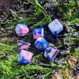 Set di sette dadi poliedrici Ionic Storm con vortici blu, rosa, bianchi e neri e numeri dorati su alghe verdi