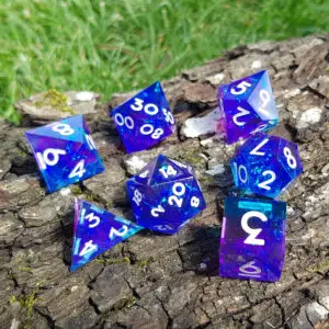 Set di sette dadi in resina a spigolo vivo Nebula Crownstones, blu e viola con glitter e numeri bianchi su corteccia