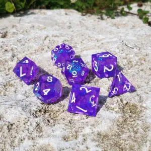Set Starlit Arcanum di sette dadi poliedrici in resina a spigolo vivo, viola con glitter blu e numeri bianchi su pietra chiara