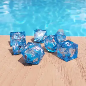 Set di sette dadi Stellar Blue Lake in resina a spigoli vivi, blu con nucleo liquido glitterato e numeri argento