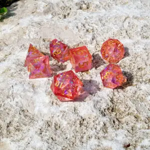 Set di sette dadi Emberblossom Crystals in resina rossa trasparente a spigoli vivi, glitter olografici e numeri dorati su pietra