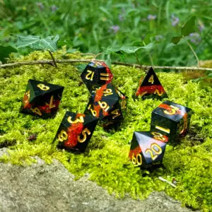 Set di dadi in resina a spigoli vivi Obsidian Shards: Glowing Ember, neri con glitter rossi e numeri dorati sul muschio