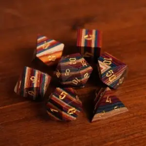 Set Spellgrain di sette dadi poliedrici in legno a strisce rosse, blu, arancio e crema con numeri gotici dorati
