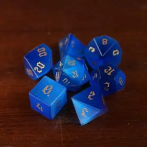 Set Panther's Gaze di sette dadi poliedrici in pietra occhio di gatto blu con numeri gotici dorati su legno scuro