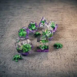 Set di sette dadi Bog Witch Familiar in resina trasparente e viola con rane verdi incluse, accanto a piccole rane