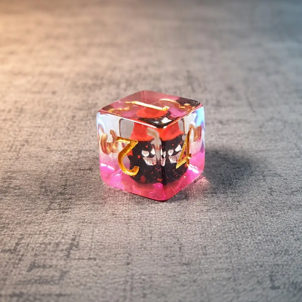 Crimson Ghost Core – Set di Dadi in Resina con Miniature 2 D6 Crimson Ghost Core in resina trasparente rosa con fantasmino nero e rosso all'interno e numeri dorati, su tessuto grigio