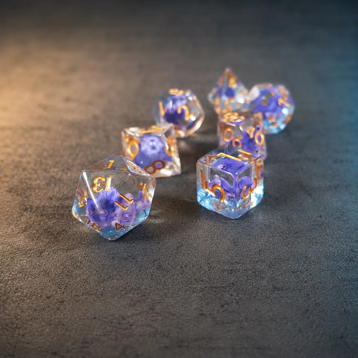 Lilac Shellback – Set di Dadi in Resina con Miniature 1 Set di dadi Lilac Shellback: sette dadi in resina trasparente con tartarughe viola all'interno e numeri dorati su fondo grigio