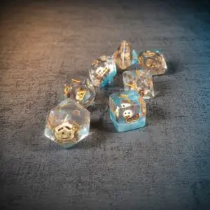 Set di sette dadi in resina Monkey Business, trasparenti con venature azzurre, scimmiette interne e numeri dorati su tessuto grigio