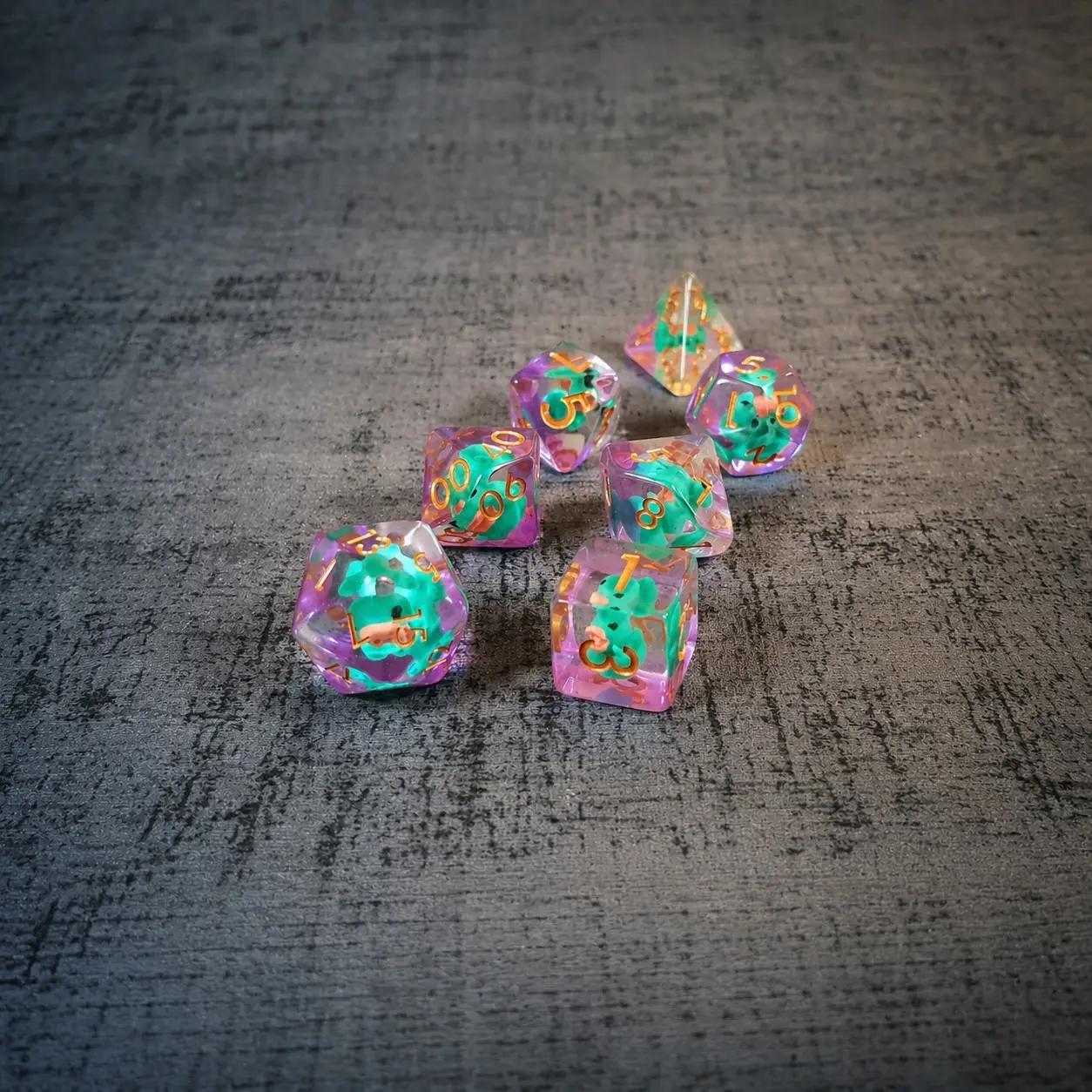 PERRY the Duck resin dice set: seven clear pink-edged dice with teal duck inclusions and orange numbers on grey fabric