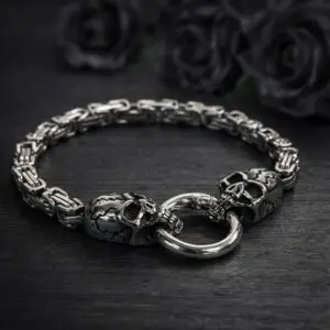 Bracciale in metallo argentato The Twin Skulls’ Oath con maglia bizantina e due teschi crepati che reggono un anello