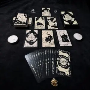 Mazzo Kitten Tarot nero e crema con carte a tema gatti come La Forza e La Giustizia, carte a ventaglio, scatola e candele