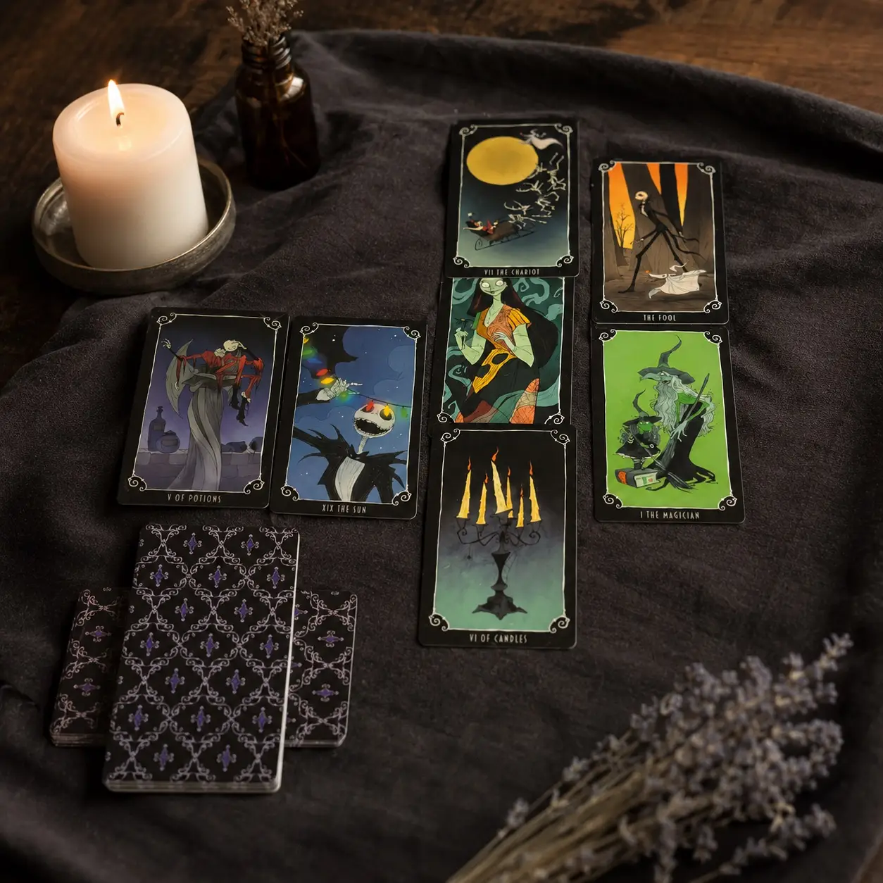 Carte dei Tarocchi Nightmare Before Christmas su panno scuro, dorsi a motivi viola, candela accesa e lavanda